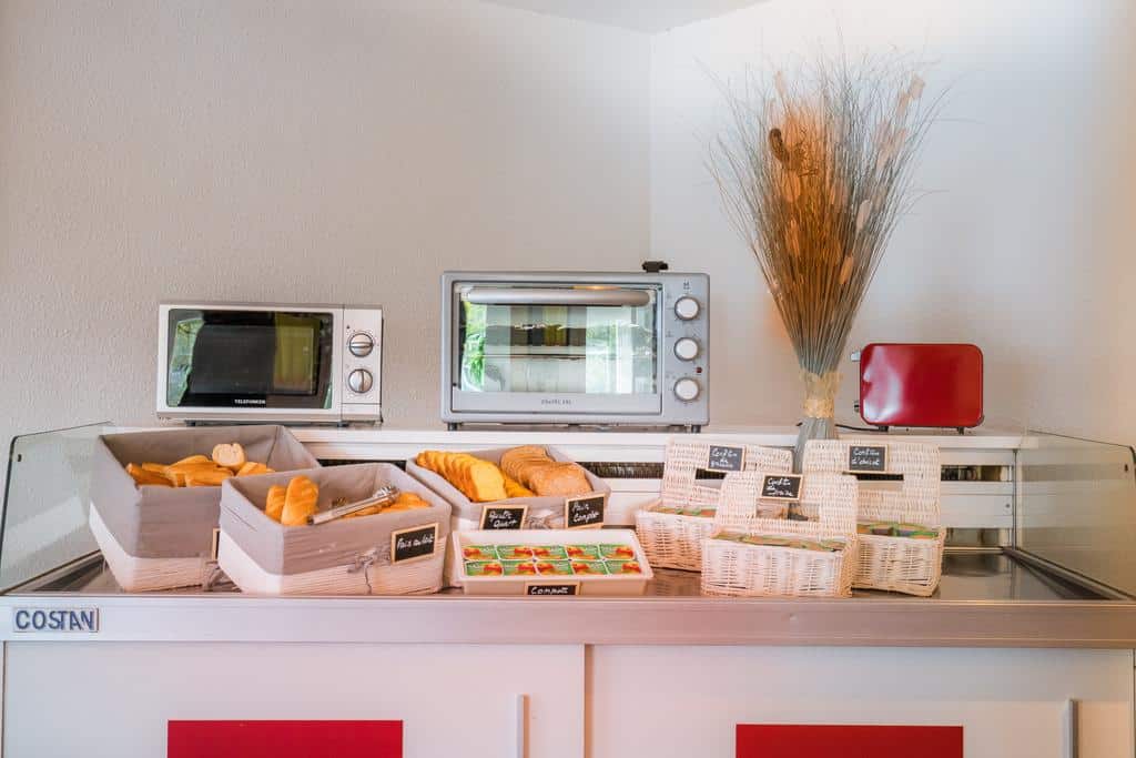 Comptoir petit-déjeuner buffet avec viennoiseries et confitures.