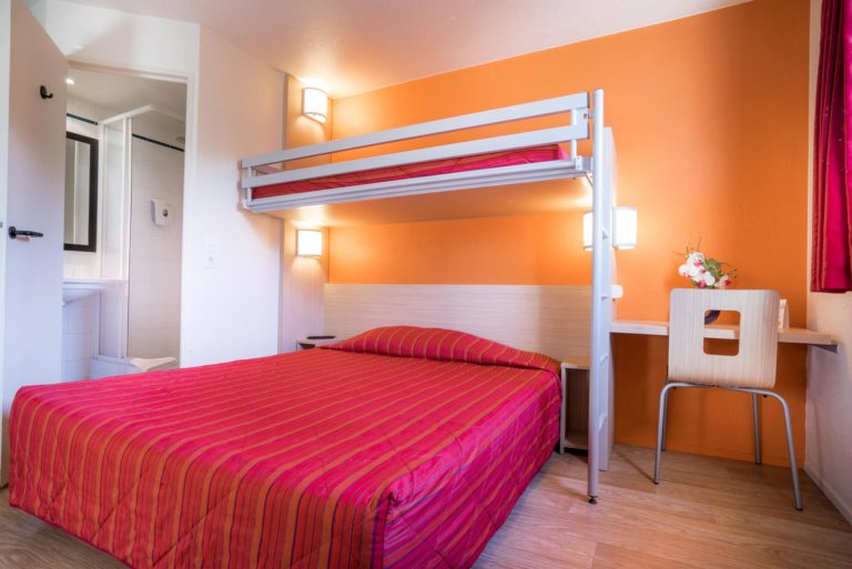 Chambre d'hôtel moderne avec lits superposés.