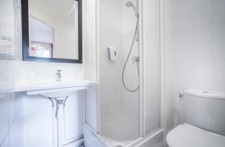 Petite salle de bain avec douche moderne et toilettes.