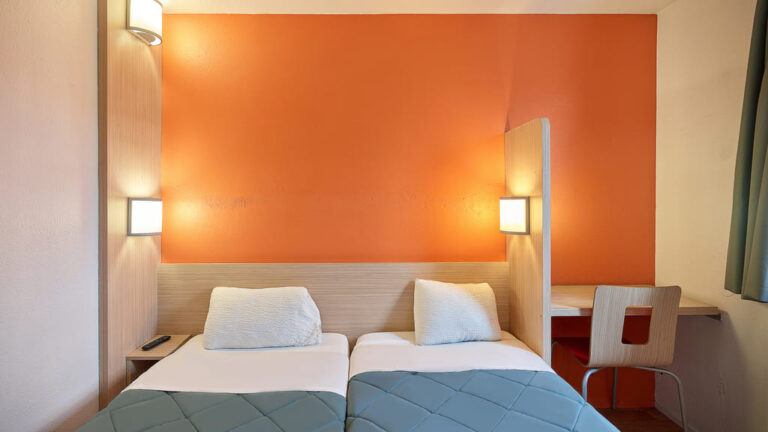 Chambre d'hôtel avec deux lits simples.